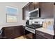 Modern kitchen with stainless-steel appliances, dark wood cabinets, and a quartz countertop, perfect for cooking at 3885 E Kenley Ln, San Tan Valley, AZ 85143