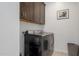 Modern laundry room with a washer and dryer and upper cabinets at 3885 E Kenley Ln, San Tan Valley, AZ 85143