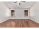 Bedroom featuring wood-look floors, ceiling fan, and two windows with blinds at 4110 W Villa Linda Dr, Glendale, AZ 85310