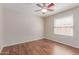 Bright bedroom with wood-look flooring, ceiling fan, and window with blinds at 4110 W Villa Linda Dr, Glendale, AZ 85310