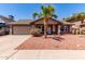 Charming single-Gathering home featuring desert landscaping, a mature palm tree, and an attached two-car garage at 4110 W Villa Linda Dr, Glendale, AZ 85310