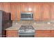 Close up of stainless steel appliances and granite countertops that complement the wooden cabinets in the kitchen at 4110 W Villa Linda Dr, Glendale, AZ 85310