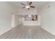 Open-concept living room with bar to kitchen, tile flooring, and ceiling fan at 4110 W Villa Linda Dr, Glendale, AZ 85310