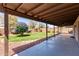 This covered patio leads to a lush yard with verdant grass and mature landscaping at 4110 W Villa Linda Dr, Glendale, AZ 85310