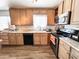 Bright kitchen features stainless appliances, wood cabinets, laminate countertops and flooring at 4623 W Mission Ln, Glendale, AZ 85302
