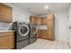 Bright laundry room with stainless steel washer and dryer and built-in cabinets at 5118 E Mulberry Dr, Phoenix, AZ 85018