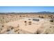 Expansive desert lot featuring a modest home and storage sheds, ideal for off-grid living at 52680 W Meadow Green Rd, Maricopa, AZ 85139