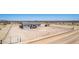 Aerial perspective of home with fenced yard on a vast dirt lot, offering solitude at 52680 W Meadow Green Rd, Maricopa, AZ 85139