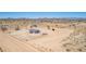 Desert property displaying a small home with outbuildings on a spacious lot, offering seclusion at 52680 W Meadow Green Rd, Maricopa, AZ 85139