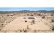 Wide aerial perspective of a desert property, showcasing a manufactured home and arid surroundings at 52680 W Meadow Green Rd, Maricopa, AZ 85139