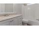 Bright bathroom with a vanity, sink, toilet, and bathtub with white tile surround at 52680 W Meadow Green Rd, Maricopa, AZ 85139