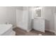 Clean bathroom features a soaking tub, walk in shower, and modern white vanity at 52680 W Meadow Green Rd, Maricopa, AZ 85139