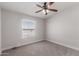 Cozy bedroom with neutral carpet, ceiling fan, and natural light from the window at 52680 W Meadow Green Rd, Maricopa, AZ 85139
