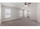 Bright bedroom featuring neutral walls, carpet flooring, a ceiling fan, and two windows at 52680 W Meadow Green Rd, Maricopa, AZ 85139