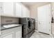 Modern laundry room with white cabinets, utility sink, granite countertop and stainless steel appliances at 5428 E Windstone Trl, Cave Creek, AZ 85331