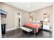 Bedroom features wood floors, mounted TV, adjoining bathroom, and minimalist decor at 5428 E Windstone Trl, Cave Creek, AZ 85331