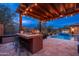 This outdoor kitchen features a built in grill, countertop seating and a view of the pool and spa at 5428 E Windstone Trl, Cave Creek, AZ 85331