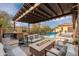 Outdoor patio with a pergola, fire pit, built in grill, and swimming pool beyond at 5428 E Windstone Trl, Cave Creek, AZ 85331