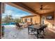 Covered patio with dining and lounge areas, ceiling fan and a view of the pool and desert landscaping at 5428 E Windstone Trl, Cave Creek, AZ 85331