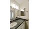 Bright bathroom featuring a granite countertop, white cabinets, decorative lighting, and mirrors at 5622 N Palacio Way, Phoenix, AZ 85014