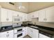 Bright kitchen featuring white cabinetry, black countertops, and stainless steel appliances at 5622 N Palacio Way, Phoenix, AZ 85014