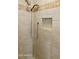 Detailed shot of tiled shower with niche and handheld sprayer at 5622 N Palacio Way, Phoenix, AZ 85014