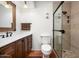 Well-lit bathroom featuring a glass-enclosed shower, and a wooden vanity with stylish fixtures at 5637 N 78Th Way, Scottsdale, AZ 85250