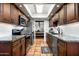 Well-lit kitchen featuring stainless steel appliances and dark wood cabinets at 5637 N 78Th Way, Scottsdale, AZ 85250