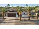 Inviting single-story home featuring desert landscaping, palm trees, and a long, paved driveway at 5802 E Spring Rd, Scottsdale, AZ 85254