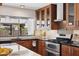 Well-lit kitchen showcasing wood cabinets, stainless steel appliances, and backyard view at 5802 E Spring Rd, Scottsdale, AZ 85254
