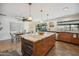 Bright kitchen boasts island with marble countertop, wood cabinets, stainless steel appliances, and sliding glass doors at 5802 E Spring Rd, Scottsdale, AZ 85254