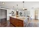 Open concept kitchen with large island, dining area, and wood flooring at 5802 E Spring Rd, Scottsdale, AZ 85254