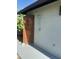Bright outdoor shower with wood door, silver shower head, and gray painted wall for easy clean up at 5802 E Spring Rd, Scottsdale, AZ 85254