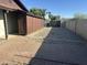 Spacious side yard with a shed, ample gravel area, and red brick pathway at 5802 E Spring Rd, Scottsdale, AZ 85254