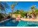 Beautiful pool area surrounded by lush greenery, palm trees, and lounge seating at 6819 E Sheena Dr, Scottsdale, AZ 85254