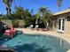 Inviting pool area with a rock waterfall feature, shaded seating, and lush landscaping at 6819 E Sheena Dr, Scottsdale, AZ 85254