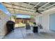 This patio with chairs, a grill, and a ceiling fan has a view of the neatly manicured backyard at 8135 N Central Ave # 1, Phoenix, AZ 85020