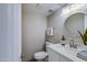 Well-lit half bathroom with white quartz countertop, round mirror, and modern sink fixtures at 8135 N Central Ave # 1, Phoenix, AZ 85020