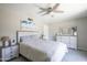 A relaxing bedroom featuring neutral tones, a ceiling fan, a dresser, and a comfortable bed with plush bedding at 8135 N Central Ave # 1, Phoenix, AZ 85020