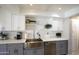 Close up of the kitchen sink featuring stainless steel appliances, quartz countertops, and modern white and gray cabinets at 8135 N Central Ave # 1, Phoenix, AZ 85020