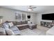 Inviting living room with a large sectional sofa, ceiling fan, and large window with natural light at 8135 N Central Ave # 1, Phoenix, AZ 85020