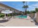 Community pool and lounge area, with multiple chairs and sun umbrellas, surrounded by palm trees at 8135 N Central Ave # 1, Phoenix, AZ 85020