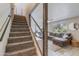 Staircase leading to a modern living room with a sectional sofa and a large window at 8135 N Central Ave # 1, Phoenix, AZ 85020