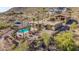 Expansive backyard featuring a pool, patio, and a well-manicured landscape, complemented by views of desert vegetation at 8752 E Range Rider Trl, Mesa, AZ 85207