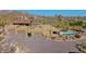 Aerial view of a private desert estate featuring a pool, multiple garages, landscaping, and mountain views at 8752 E Range Rider Trl, Mesa, AZ 85207