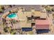 An aerial shot of an estate with a pool, and a red-roofed structure with a desert landscape at 8752 E Range Rider Trl, Mesa, AZ 85207