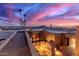 Rooftop view features city skyline, desert sunset, unique stone architecture and lush landscaping at 8752 E Range Rider Trl, Mesa, AZ 85207