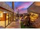 Twilight view of a stunning outdoor space with custom hardscape, boulders, and lighting for evening ambiance at 8752 E Range Rider Trl, Mesa, AZ 85207