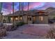Backyard featuring pool, patio, desert landscaping, cacti, succulents, and palm trees, set beneath a colorful sunset at 8752 E Range Rider Trl, Mesa, AZ 85207