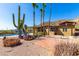 Backyard featuring pool, patio, beautiful desert landscaping, with cacti, succulents, and palm trees at 8752 E Range Rider Trl, Mesa, AZ 85207